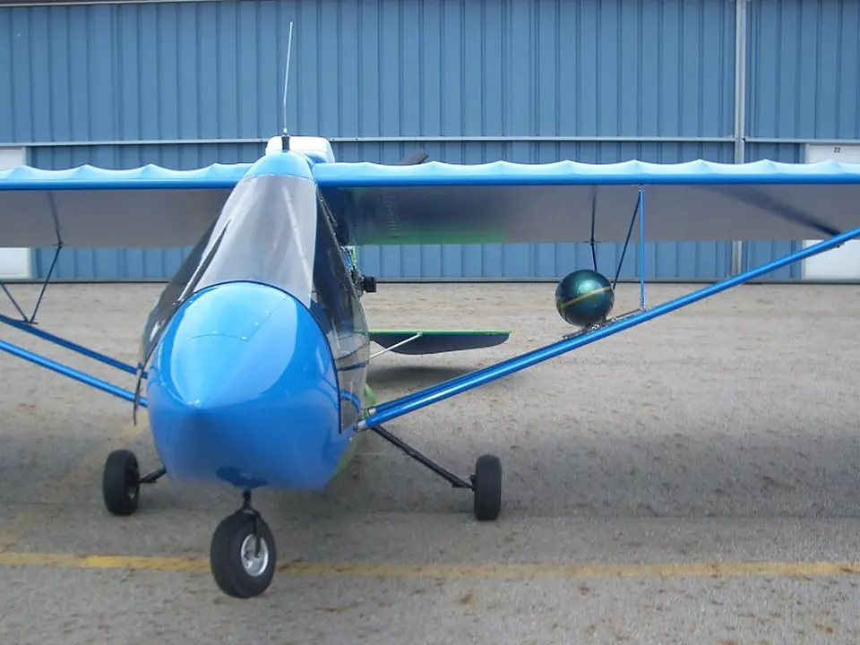 Blue and white Challenger with cargo pods parked outside the hangar